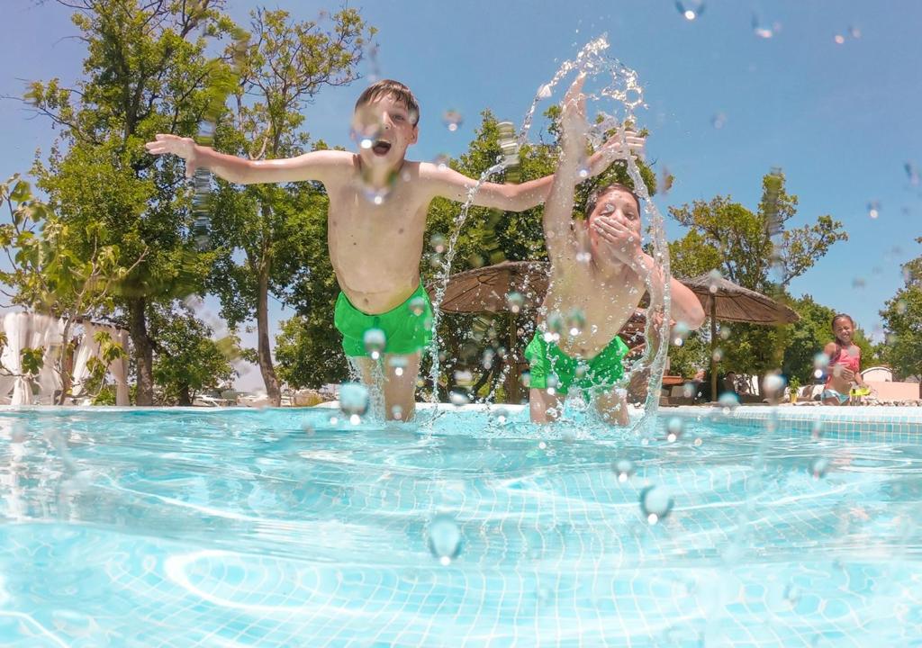 two young children playing in a swimming pool at Krk Mobile Homes in Klimno