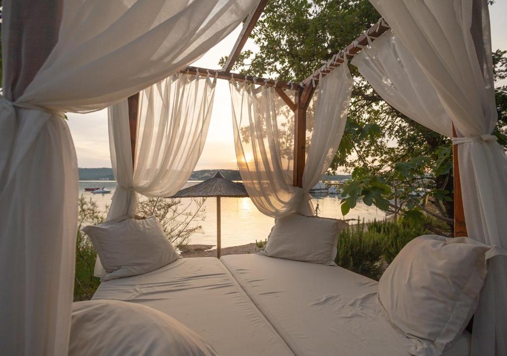 a bed in a room with a view of the water at Krk Mobile Homes in Klimno