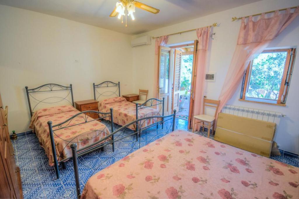 um quarto com 3 camas e uma janela em Agriturismo Galletta em Leni