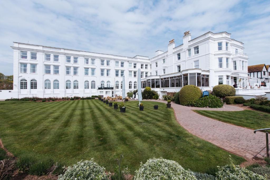 um grande edifício branco com um relvado em frente em The Palace Hotel em Paignton