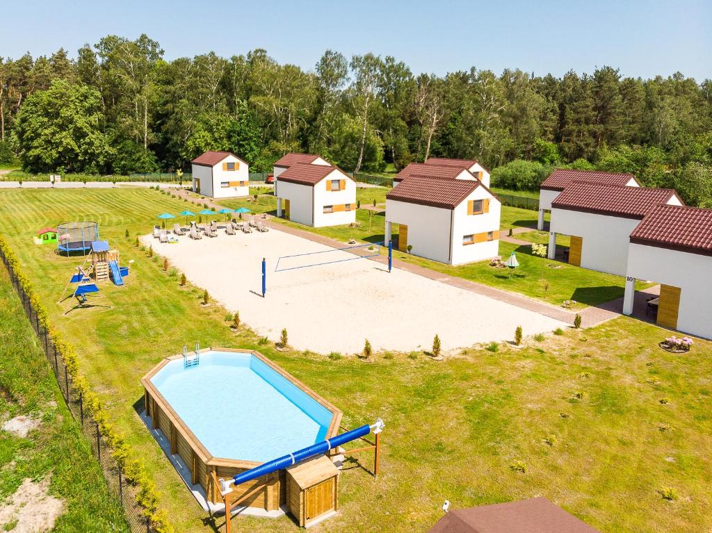 uma vista aérea de uma propriedade de resort com uma piscina e edifícios em Domki Lawendowe em Łeba