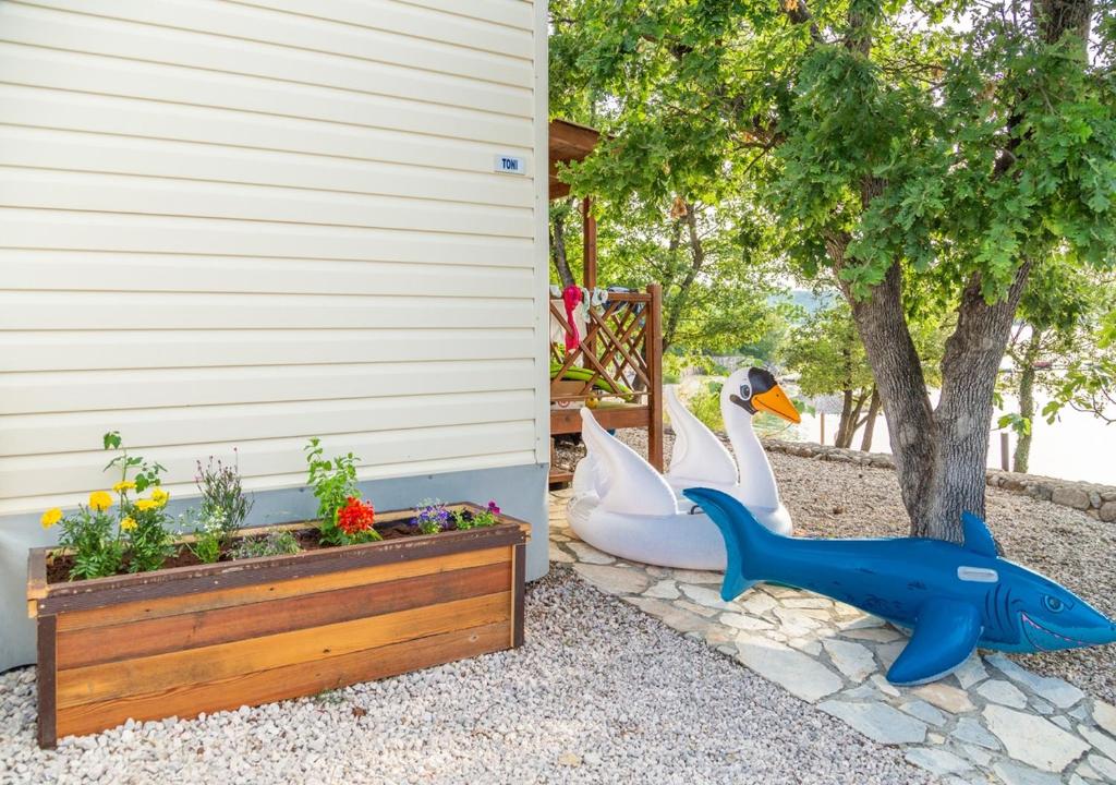 a garden with a plastic duck next to a house at Krk Mobile Homes in Klimno