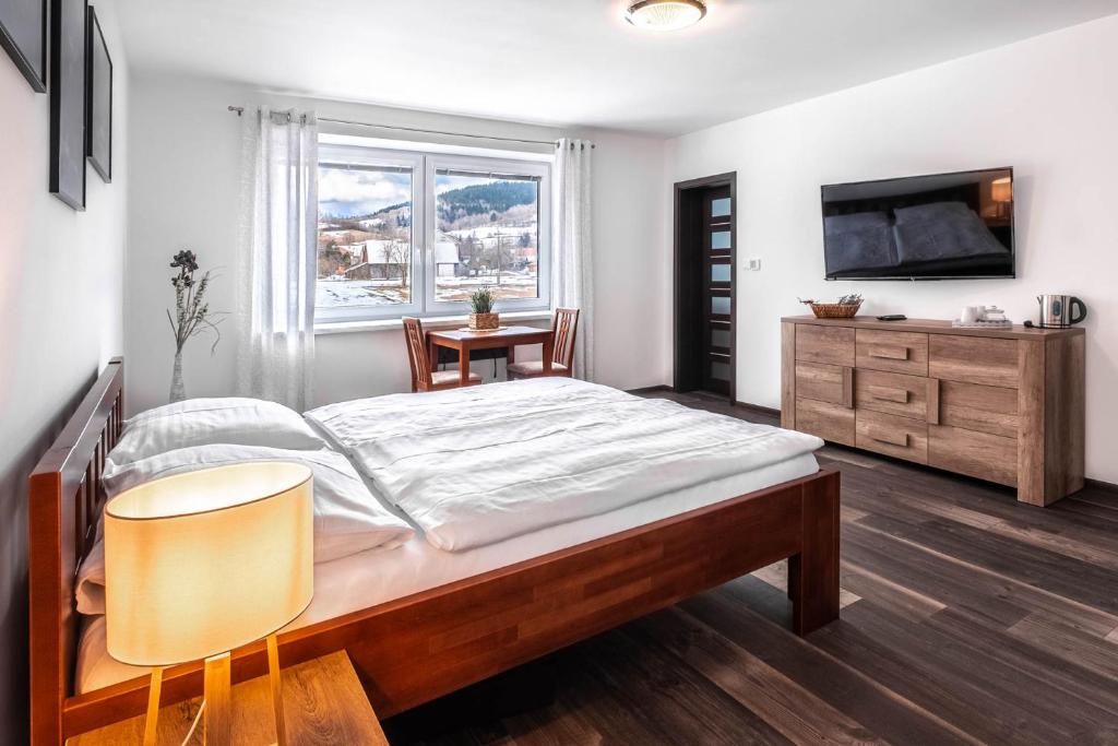 una camera con letto, TV e tavolo di Apartmány Jánošík a Terchová