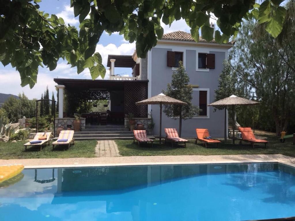 a villa with a swimming pool in front of a house at Loy Loy House in Koilás