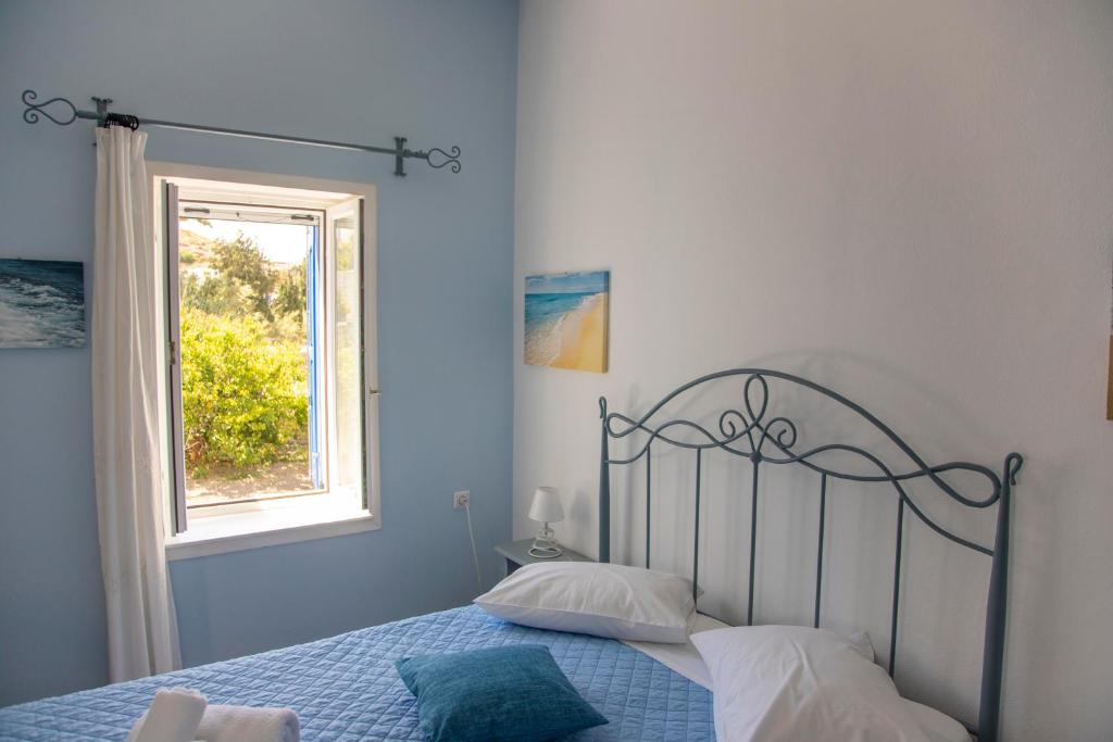 a bedroom with a bed and a window at Pension Barbara in Katapola