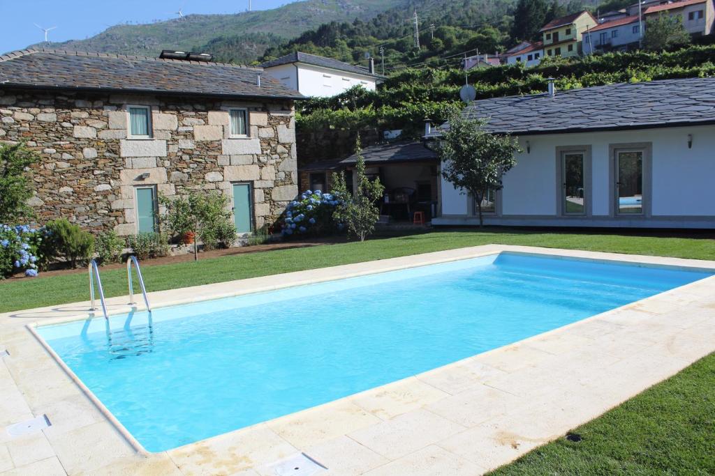 een zwembad in de achtertuin van een huis bij Recantos da Montanha in Candal