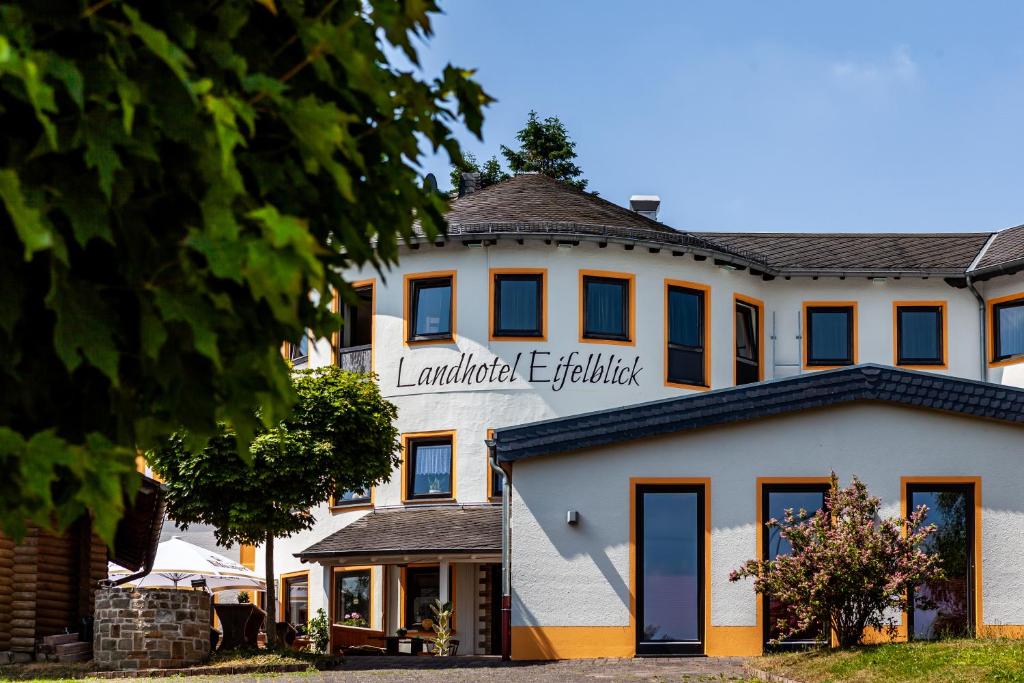 ein großes weißes Gebäude mit einem Schild drauf in der Unterkunft Landhotel Eifelblick in Stadtkyll