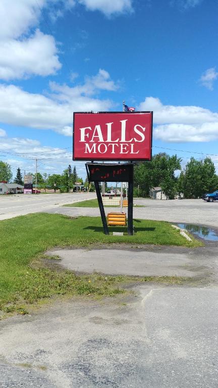 a sign for a falls motel on the side of a road at Falls Motel in International Falls