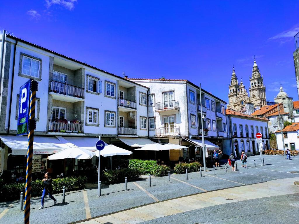 a group of buildings with umbrellas in a street at Exclusivo a 100 metros de la Catedral in Santiago de Compostela