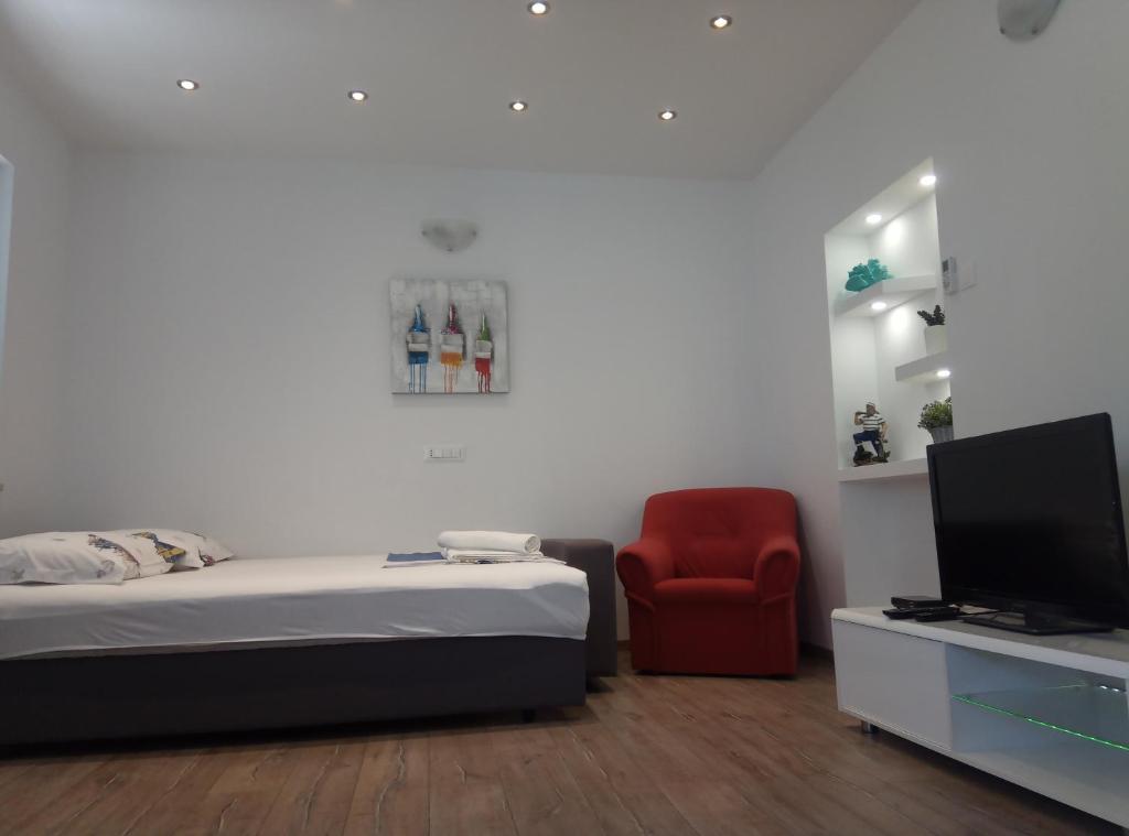Apartment Luka في ماكارسكا: غرفة نوم بسرير وكرسي احمر