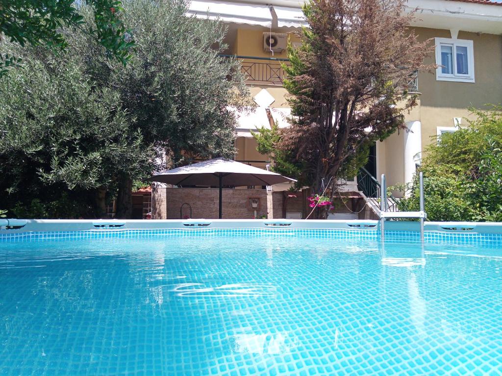 ein leerer Pool mit Sonnenschirm und Sonnenschirm in der Unterkunft maisonette with garden in Peraia