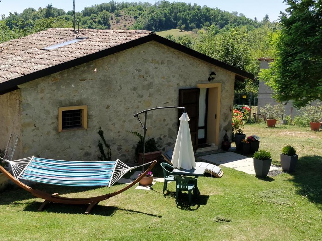 un patio con una silla y una sombrilla en B&B Il Castellaro Zocca, en Zocca