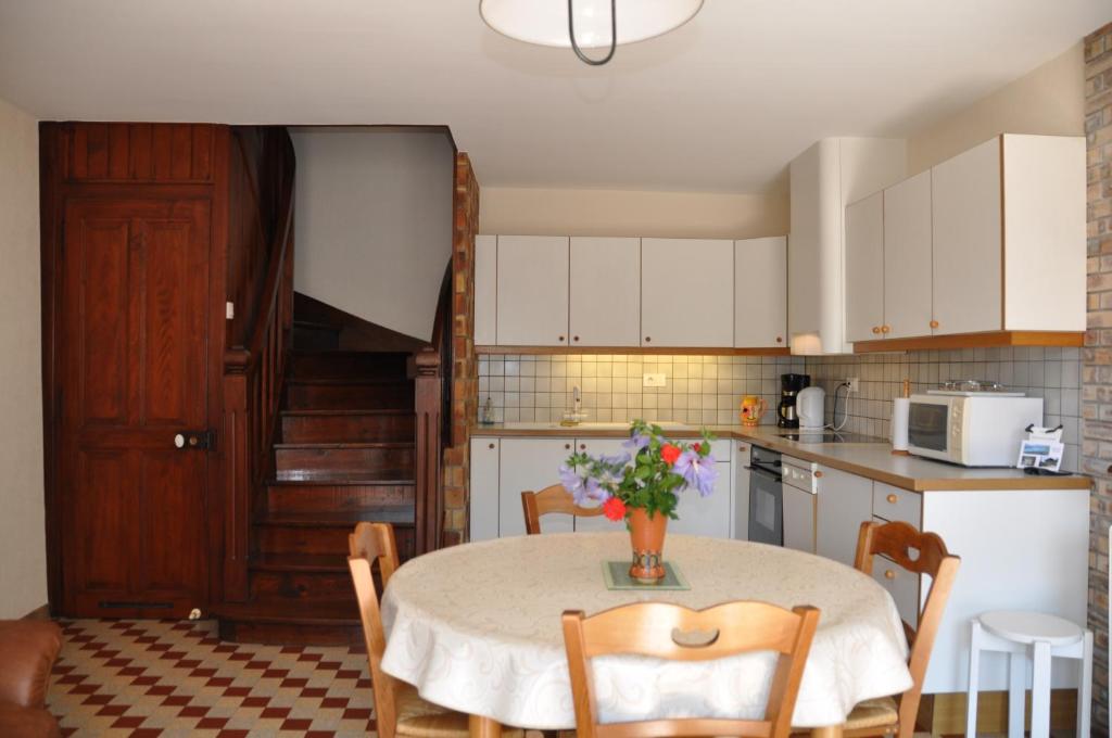 a kitchen with a table with a vase of flowers on it at Les Weitchiis in Veyrier-du-Lac