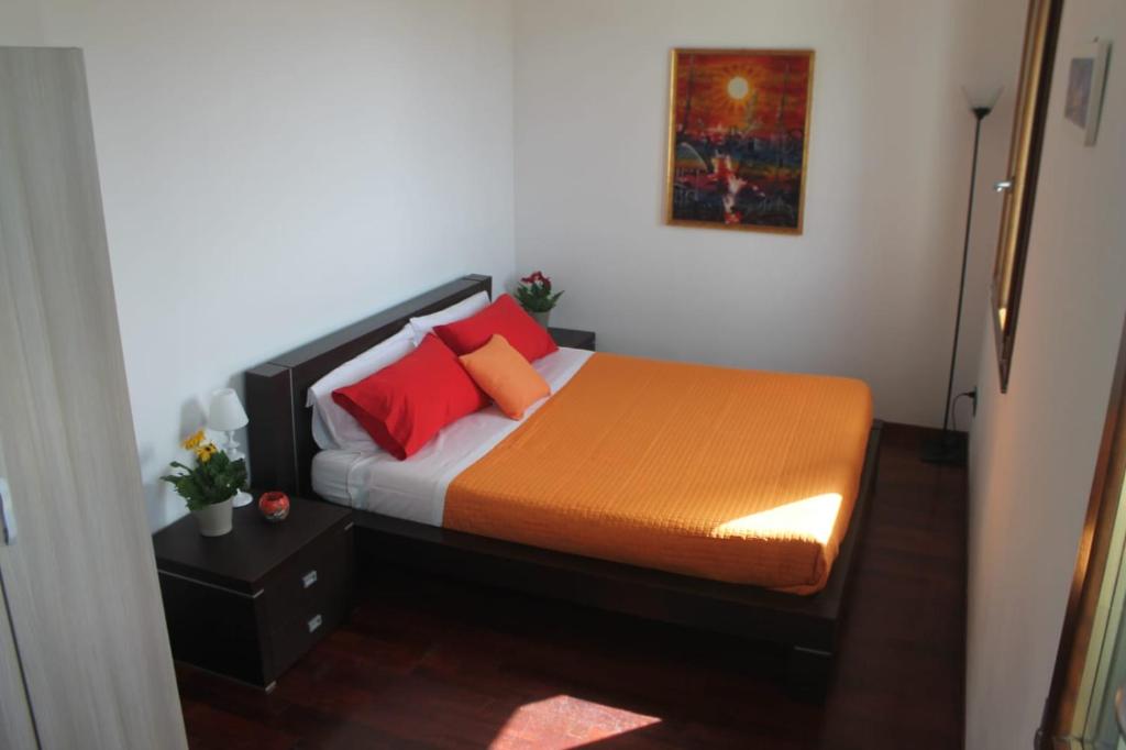 Schlafzimmer mit einem Bett mit orangefarbenen und roten Kissen in der Unterkunft B&B DA CHIARA SEA SIGHT in Sorrent