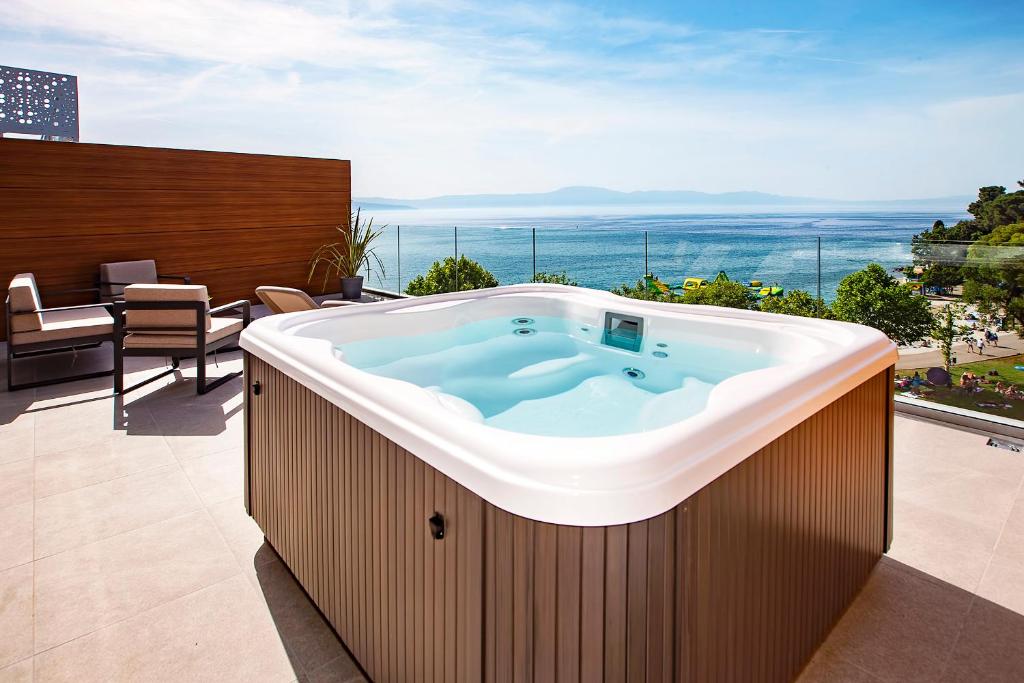 a hot tub on the balcony of a house at Luxury Hotel Riva in Malinska