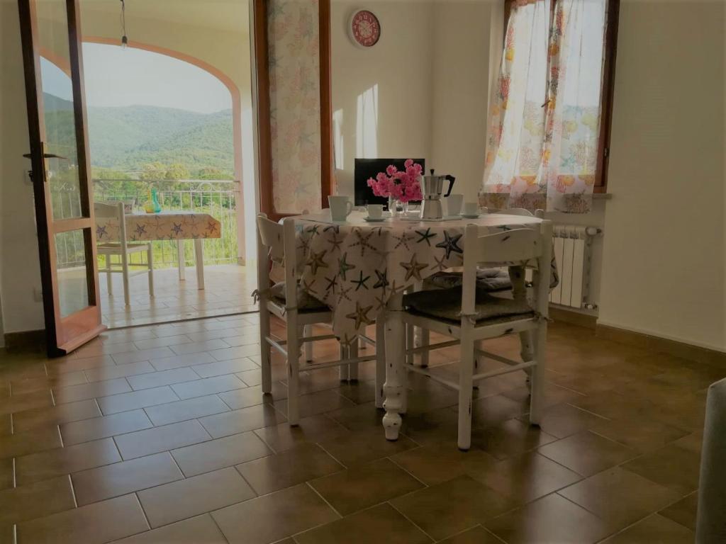 d'une salle à manger avec une table, des chaises et une fenêtre. dans l'établissement casa Gaia 2, à Portoferraio