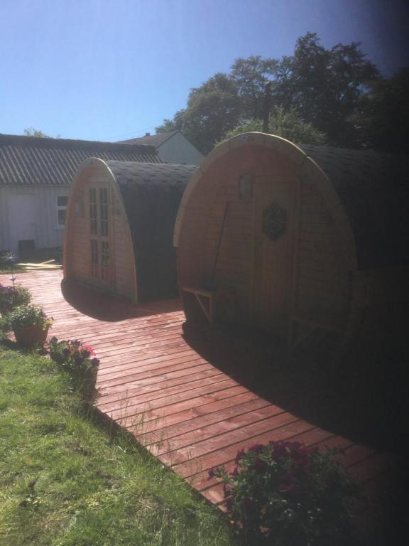 dos grandes barriles de madera sentados en una terraza de madera en The Shielings by Inverlochy Villas, en Fort William