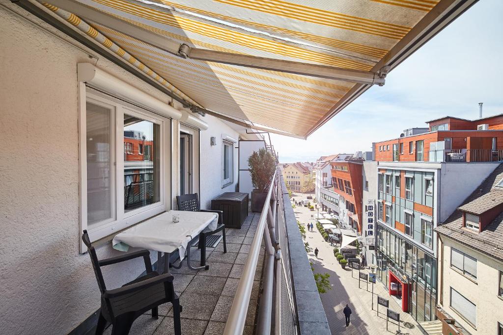 een balkon met een tafel en stoelen op een gebouw bij Casa Pinos City in Friedrichshafen