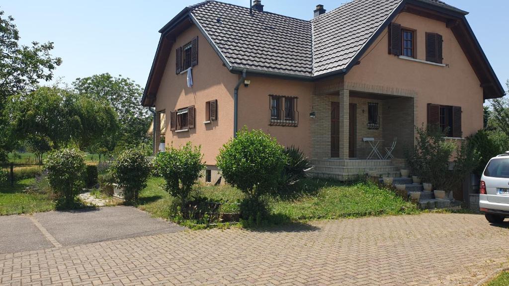 a house with a car parked in front of it at location à la campagne aux portes de Mulhouse in Sausheim