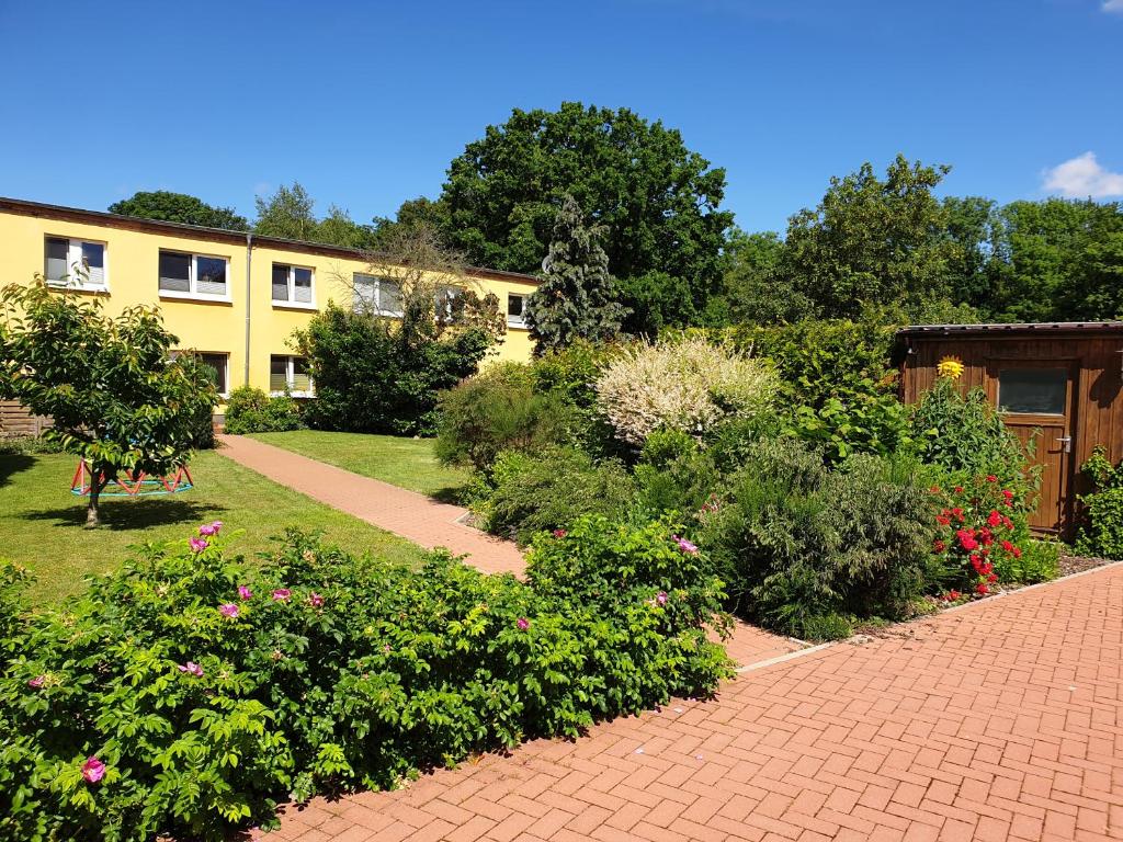 un camino de ladrillo frente a un edificio con flores en Ferienwohnung Rügen in Samtens, en Samtens