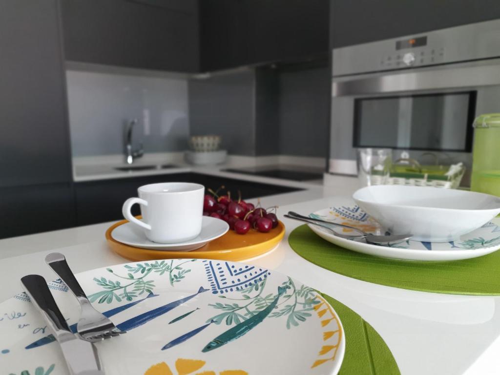 eine Küche mit einem Tisch mit Tellern und einer Kaffeetasse in der Unterkunft Bruma Marina in A Guarda