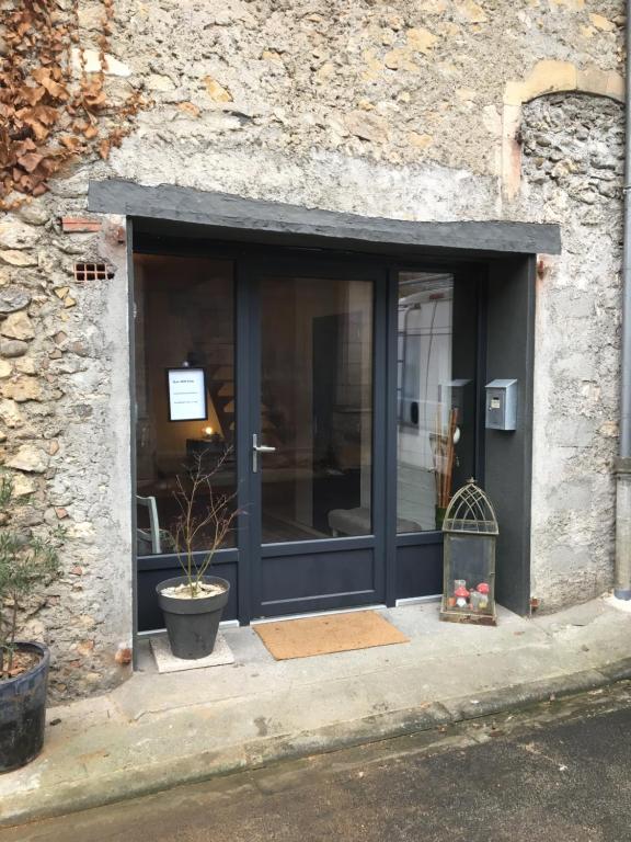 Saint-Martory的住宿－le 25bis，商店的窗户,里面装有盆栽植物