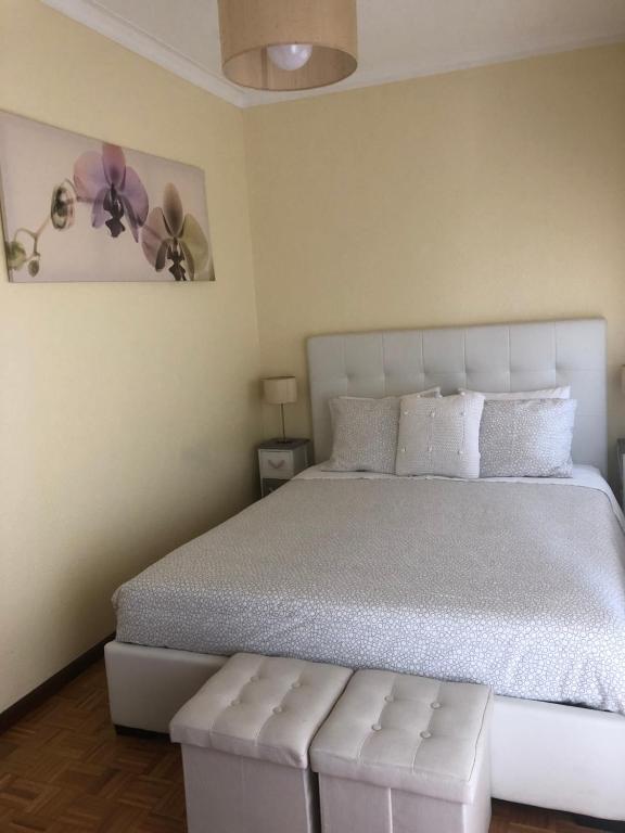 a bedroom with a white bed with a white headboard at Starfish House in Vila Nova de Gaia