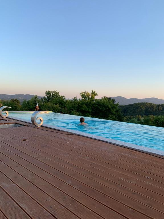 un hombre en una piscina en una terraza de madera en B&B Villa Angelina en Rogaška Slatina