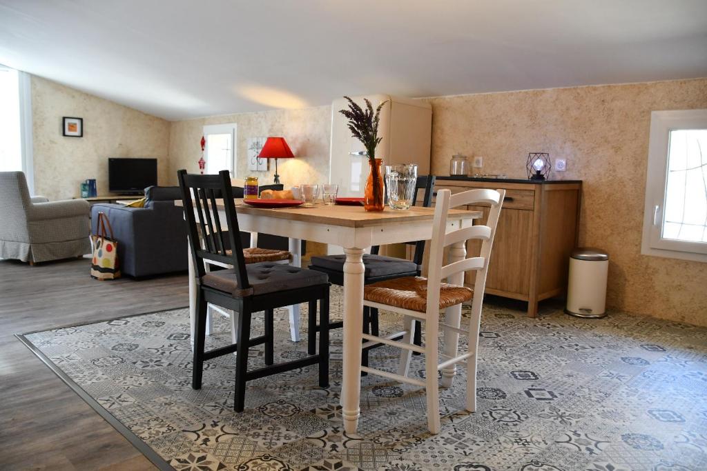 eine Küche mit einem Tisch und Stühlen im Zimmer in der Unterkunft Le pigeonnier in Malaucène