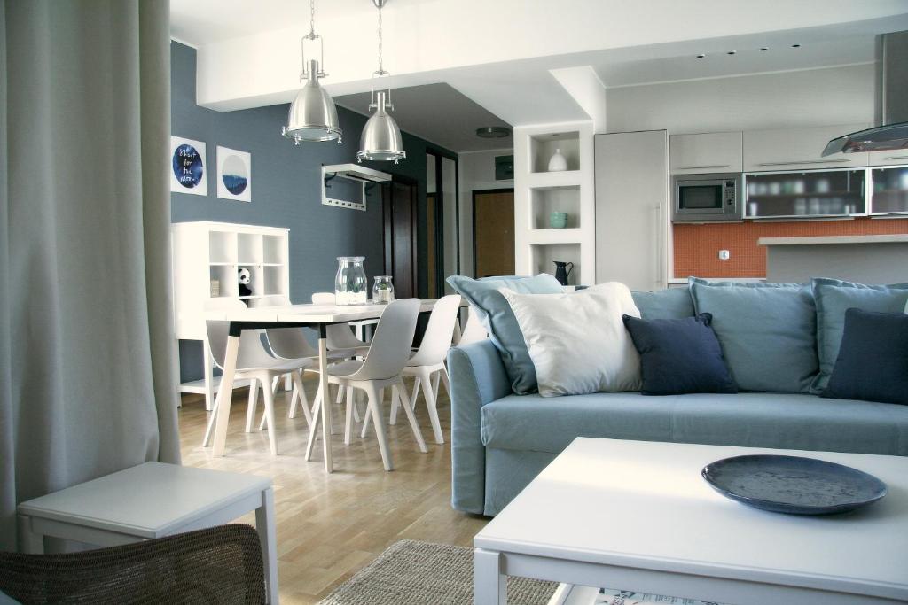a living room with a blue couch and a table at Siesta Apartments in Sopot