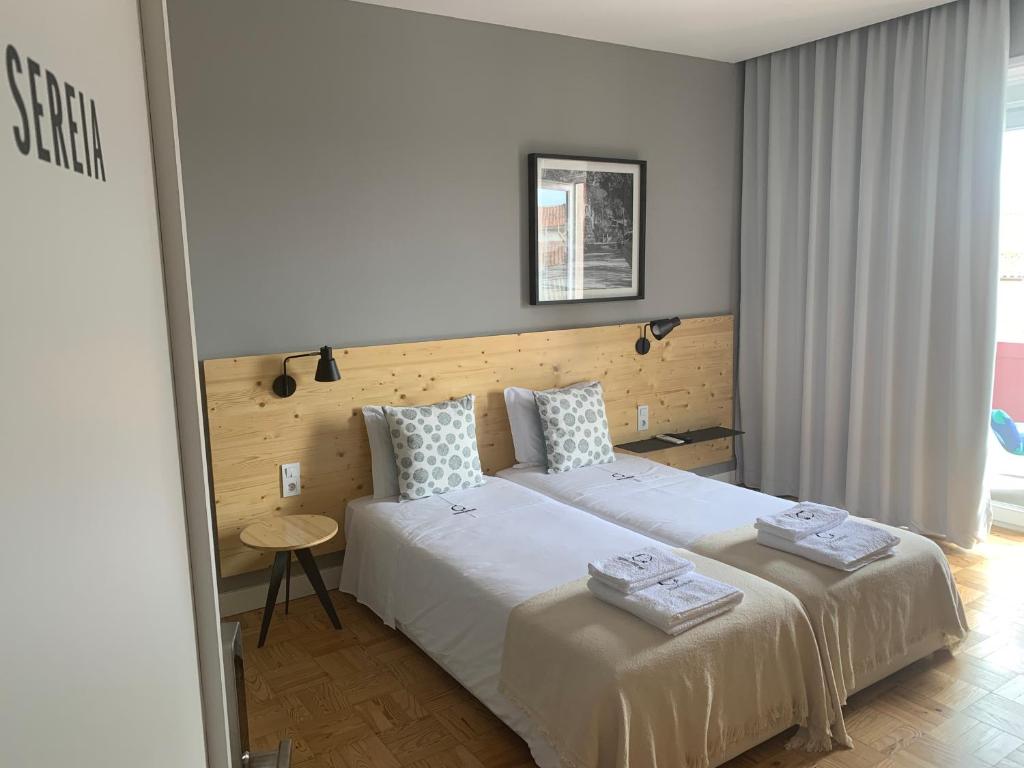 a bedroom with two beds with towels on them at Casa dos Carvalhos in Coimbra