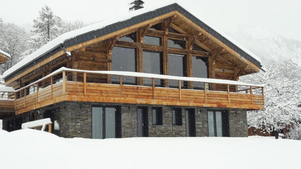 una cabaña de madera en la nieve con nieve en chalet des grands bois, en Les Houches
