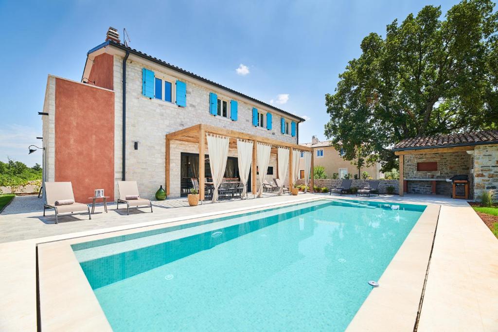 a swimming pool in front of a house at Villa Celeste in Umag
