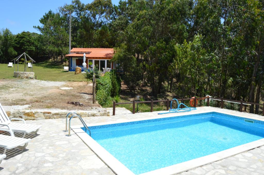 a swimming pool in a yard with a house at Quinta dos Mangues in São Martinho do Porto