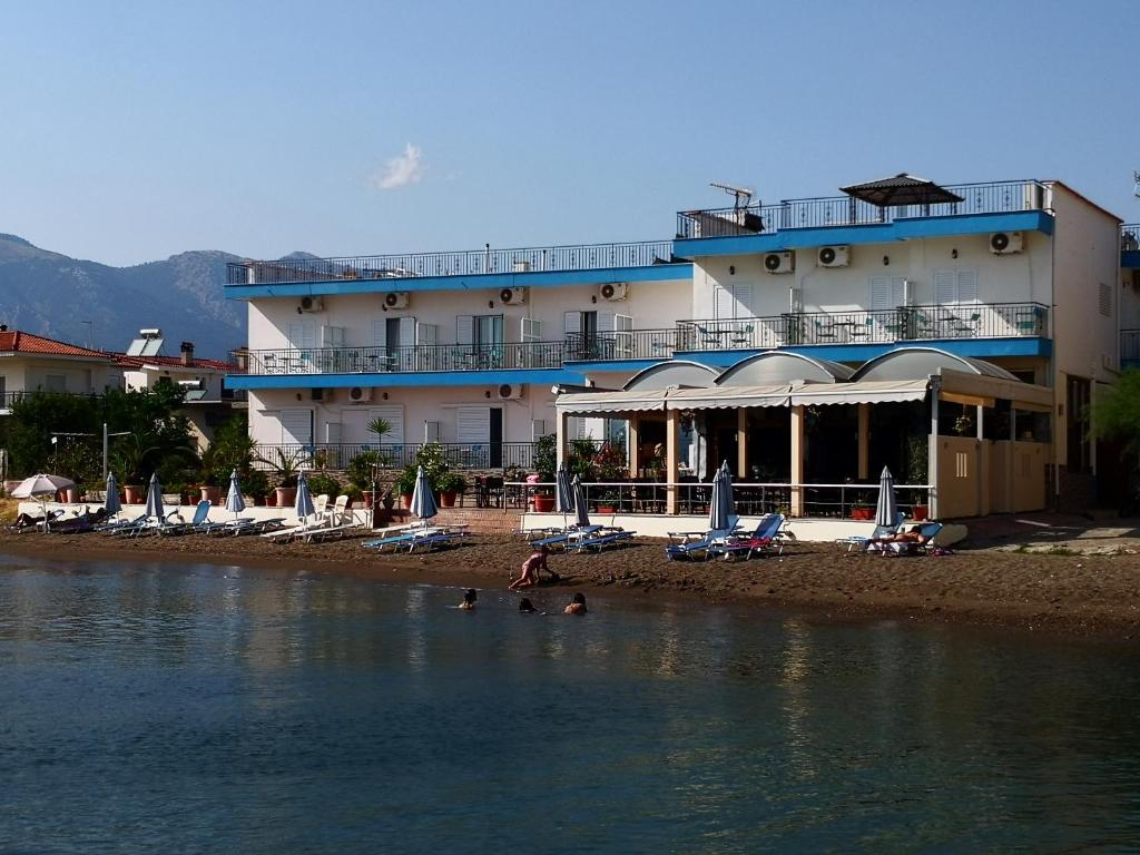 un hotel en la playa con gente nadando en el agua en Artemis Hotel, en Amarinto