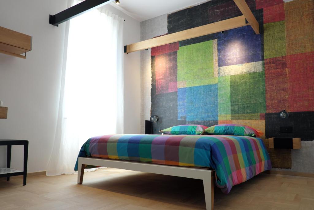 a bedroom with a bed with a colorful wall at INVENTO bnb unconventional maison in Civitanova Marche
