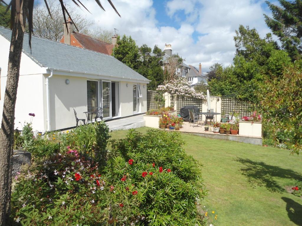 a small white house with a yard with flowers at Chy Lowarth in Penzance