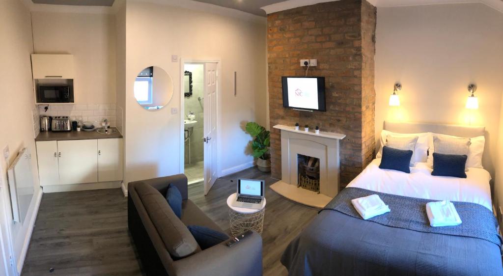 a bedroom with a bed and a living room at The Bold St LiverPods by Serviced Living Liverpool in Liverpool