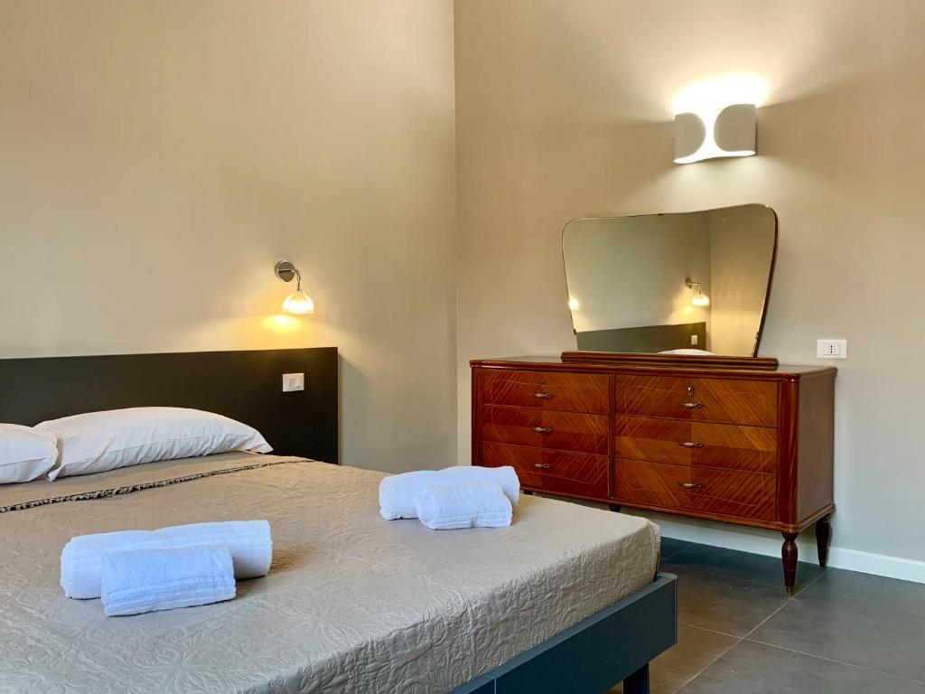 a bedroom with a bed and a dresser with a mirror at Maison A in La Spezia