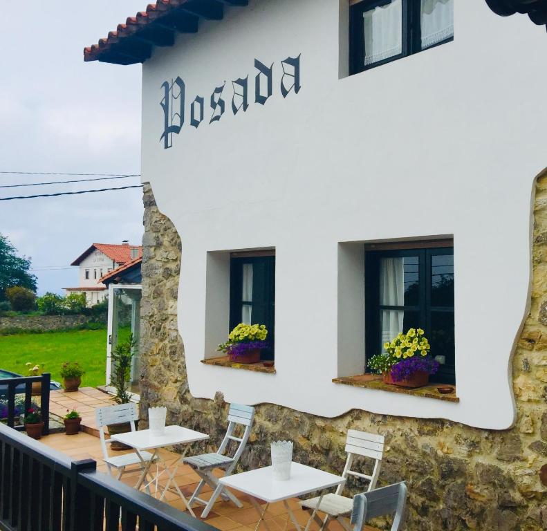 un restaurante con mesas y sillas frente a un edificio en Posada Mellante, en Pechón