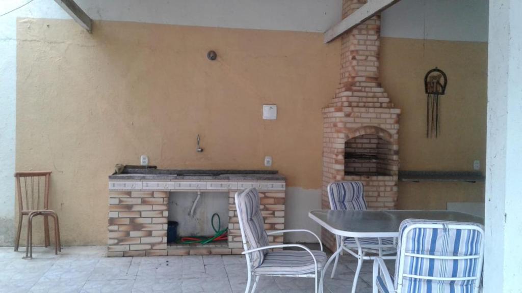聖佩德羅－達阿爾德亞的住宿－Casa Temporada Balneario de Sao Pedro Cabo Frio，庭院设有桌椅和砖砌壁炉。
