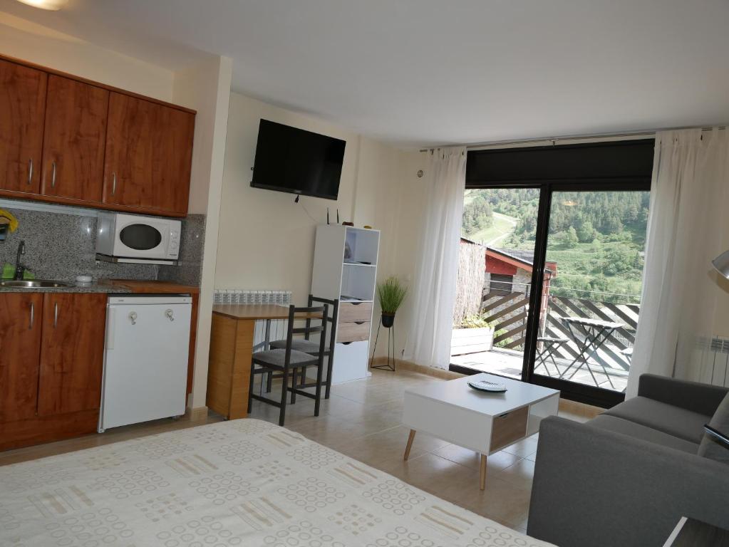 een kamer met een keuken en een woonkamer bij Genciana-Vacances Pirinenca in El Tarter