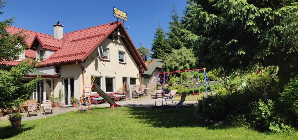 een huis met een speeltuin in de tuin bij Gościniec Saba in Zieleniec