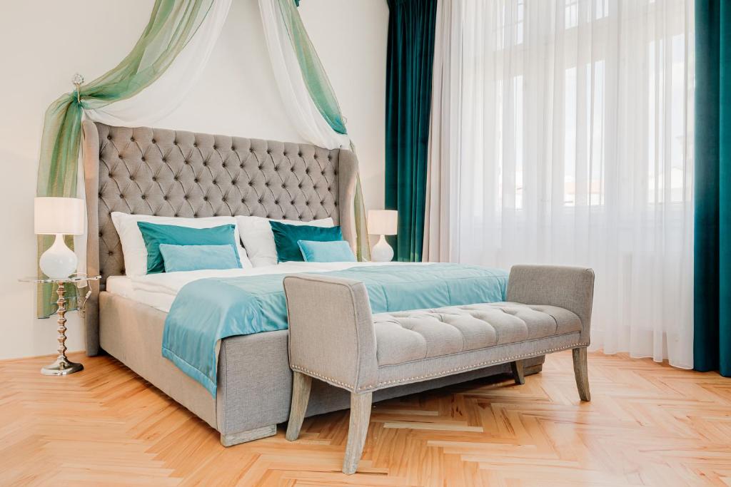 a bedroom with a large bed and a chair at Gold Art Apartments in Prague