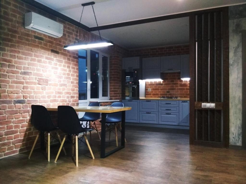 een keuken met een tafel en stoelen en een bakstenen muur bij LOFT - Interior design apartments in Oral