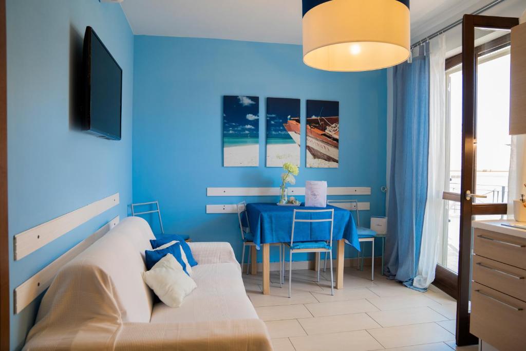 アルバ・アドリアティカにあるAppartamenti Abruzzo Rabelの青いリビングルーム(テーブル、ソファ付)