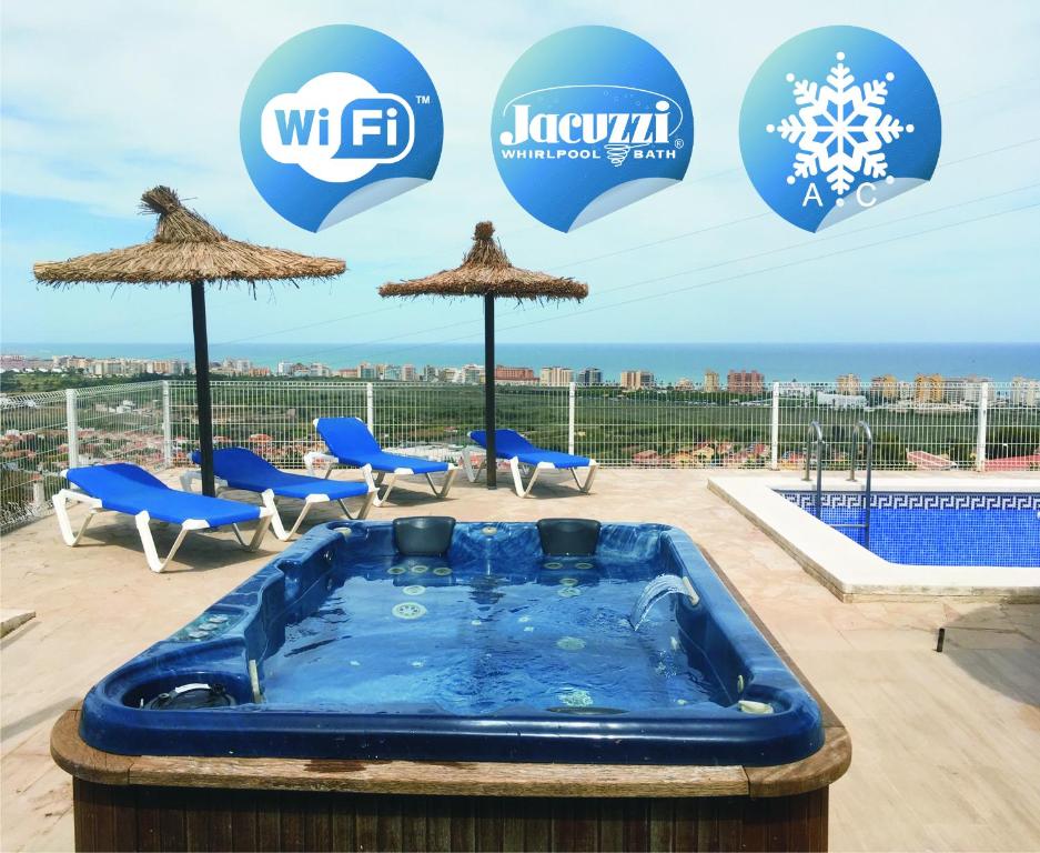 a hot tub on a roof with umbrellas at Apartamentos Vistalmar in Peñíscola