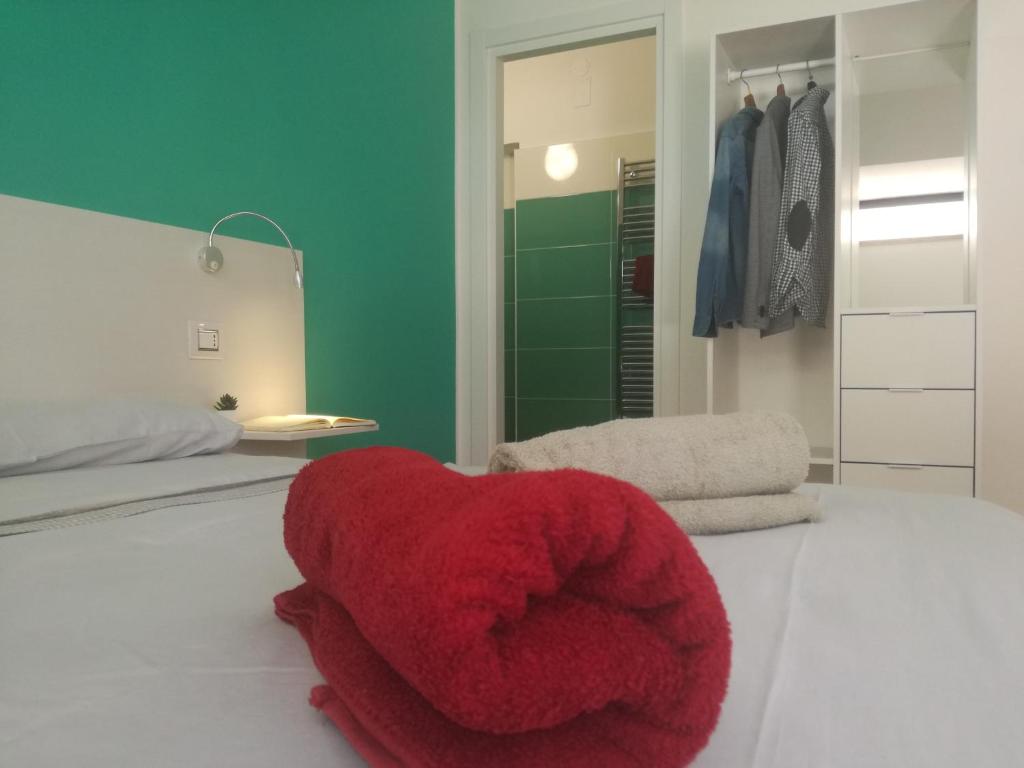 un otomano rojo sentado en una cama en un dormitorio en B&B Villa Napoli, en Battipaglia