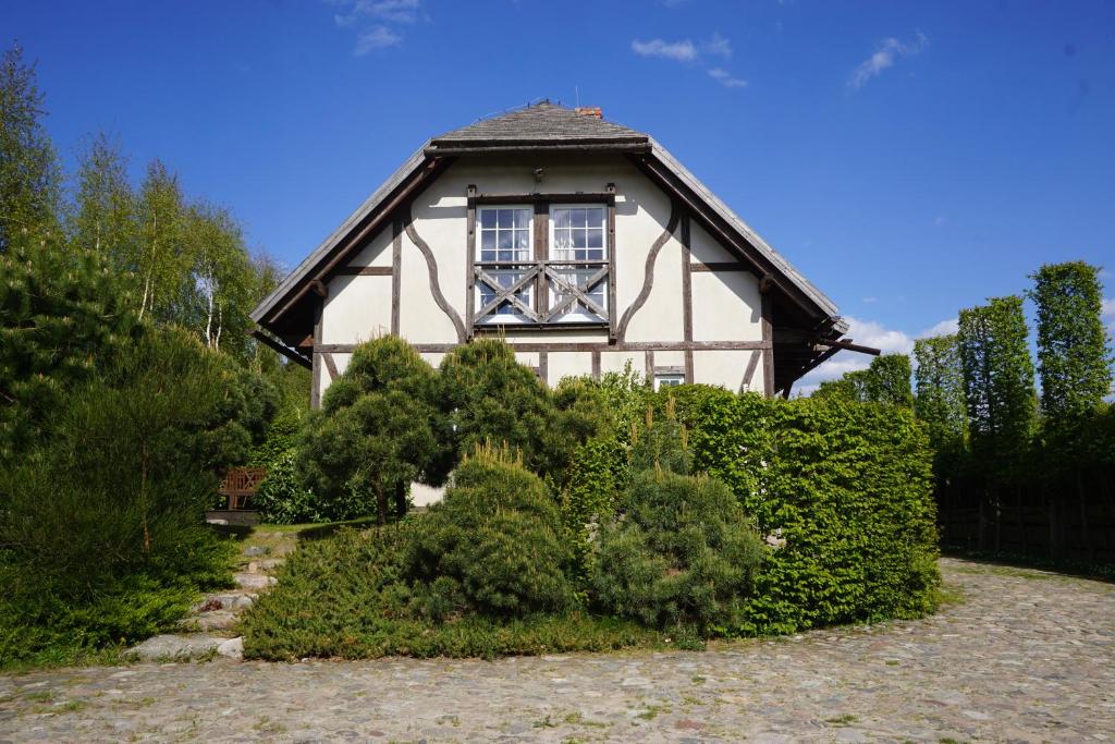 ein Haus mit einem Fenster und einigen Büschen in der Unterkunft Mały Kazimierz Dębina in Ustka