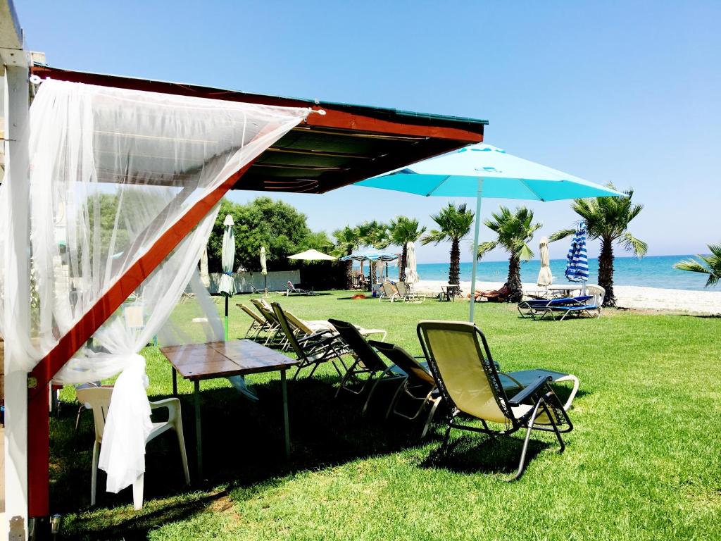 une table, des chaises et un parasol sur l'herbe dans l'établissement House Mesopotamias 32, à Larnaka